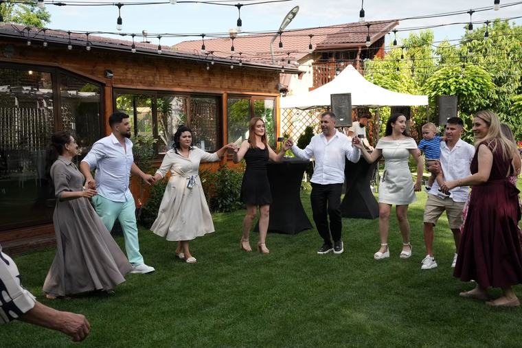 Invitați dansând hora în grădină
