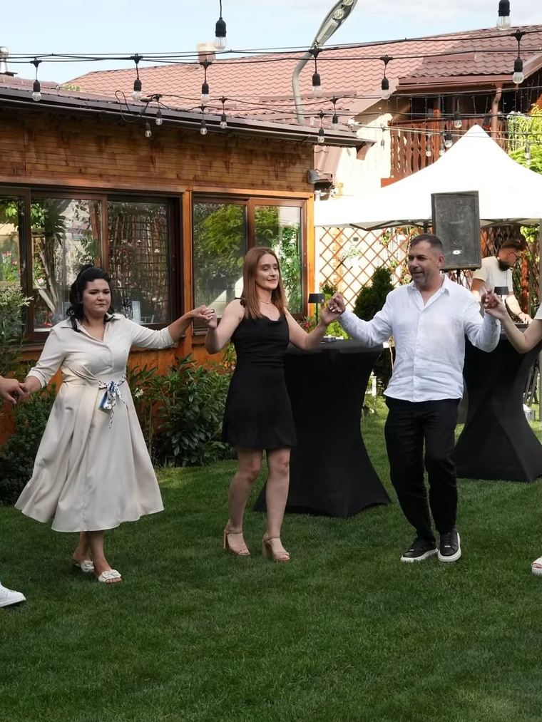 Invitați dansând hora în grădină